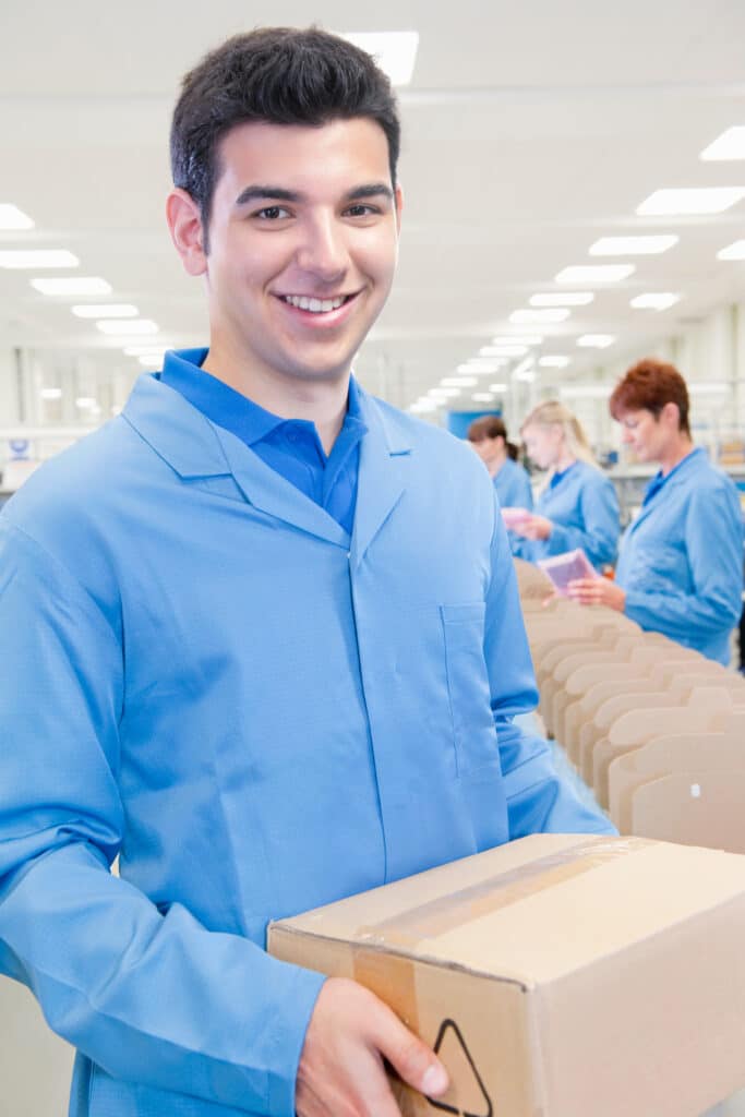 A young man in a lab coat packaging medical supplies for distribution