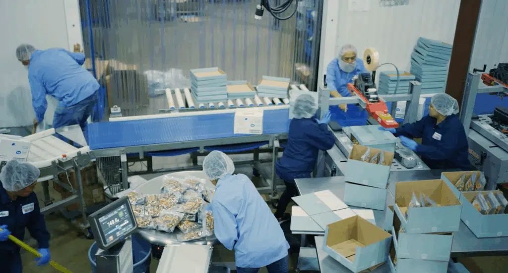 An aerial view of employees packaging orders at a snack distribution company