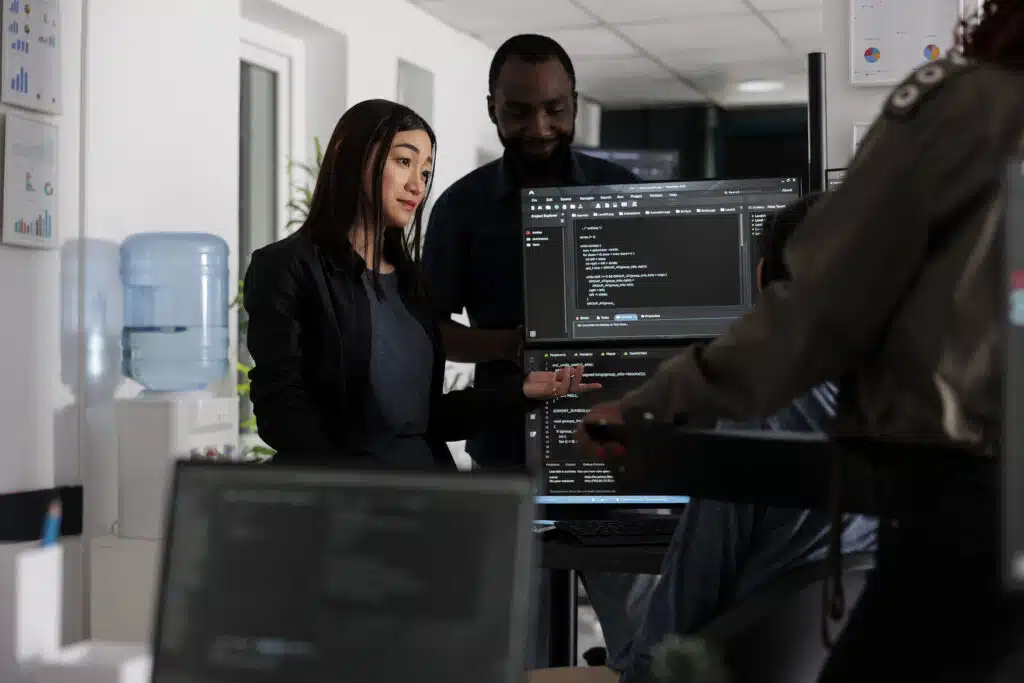 Multi ethnic programmers checking source code and database