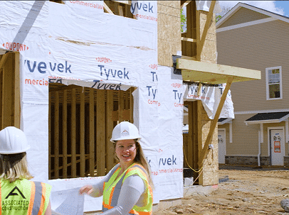 Female contractors construction workers at a residential building site with Tyvek wrap