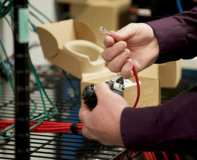 Tech Companies- Man holding red ethernet cable