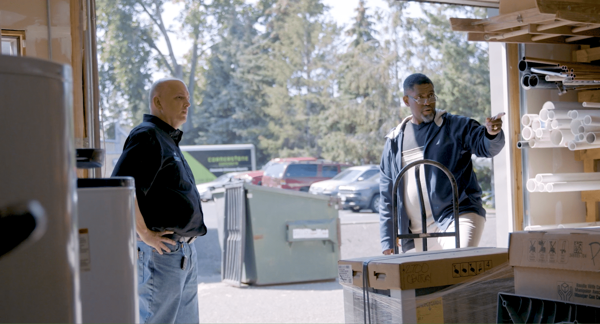 KB Service Co. St. Paul, MN. A2. 2 men in an open garage looking at boxed up product