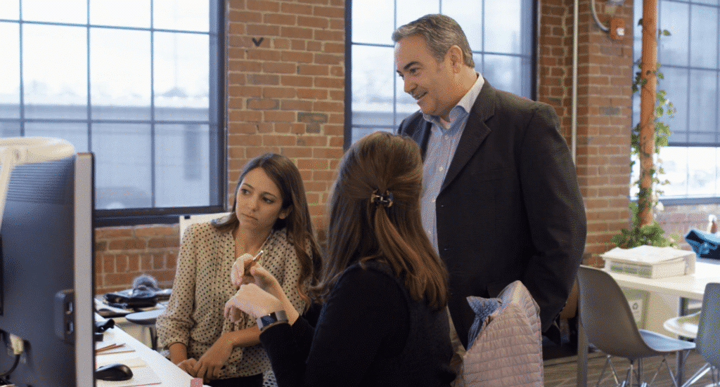 Tuck-Hinton Architects. Nashville, TN. D2. a man and 2 women engaging in a computer screen