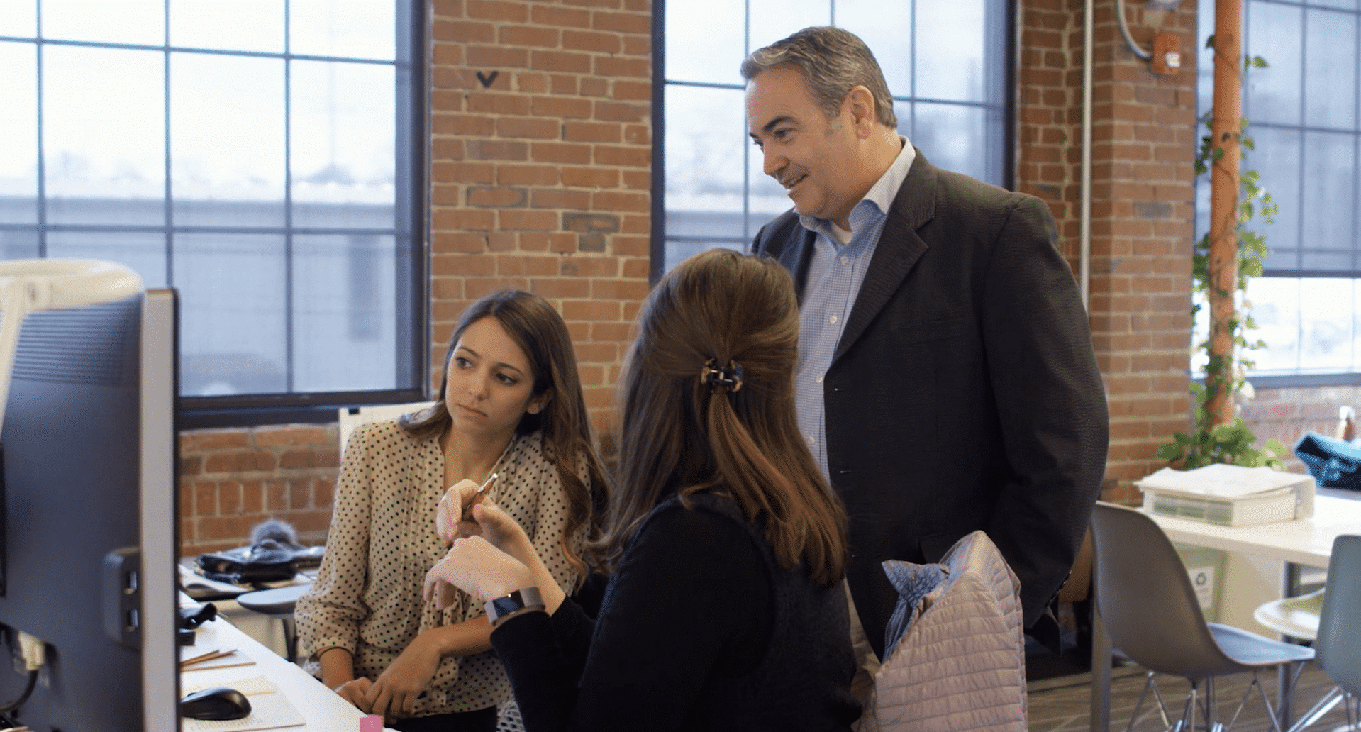 Tuck-Hinton Architects. Nashville, TN. D2. a man and 2 women engaging in a computer screen