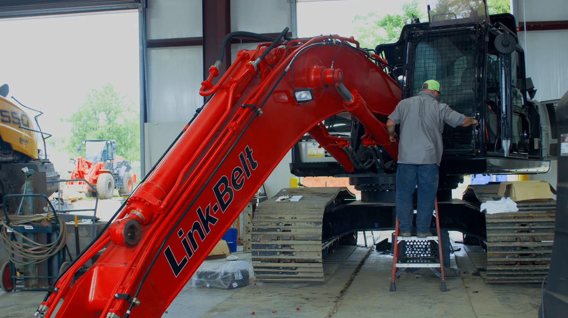 Heavy Machines Inc. Piperton, TN. C1. Specializes in forestry, scrap and heavy construction applications. Man in hat in front of a large machine.