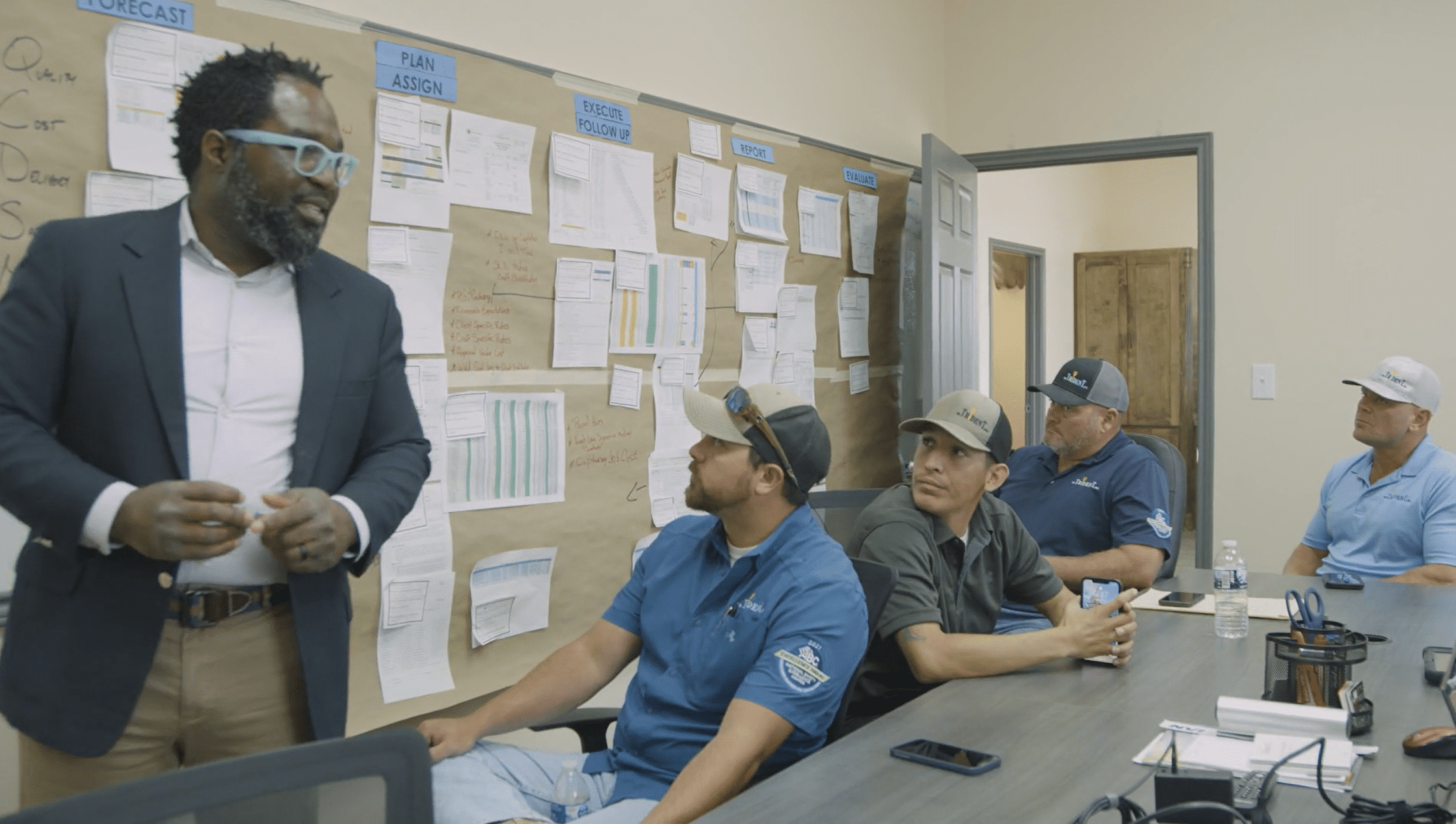 SR Trident, Inc. based in Gregory, Texas. Specializing in Industrial, Marine, and Civil Construction. Man in glasses teaching a group of 4 in the conference room.
