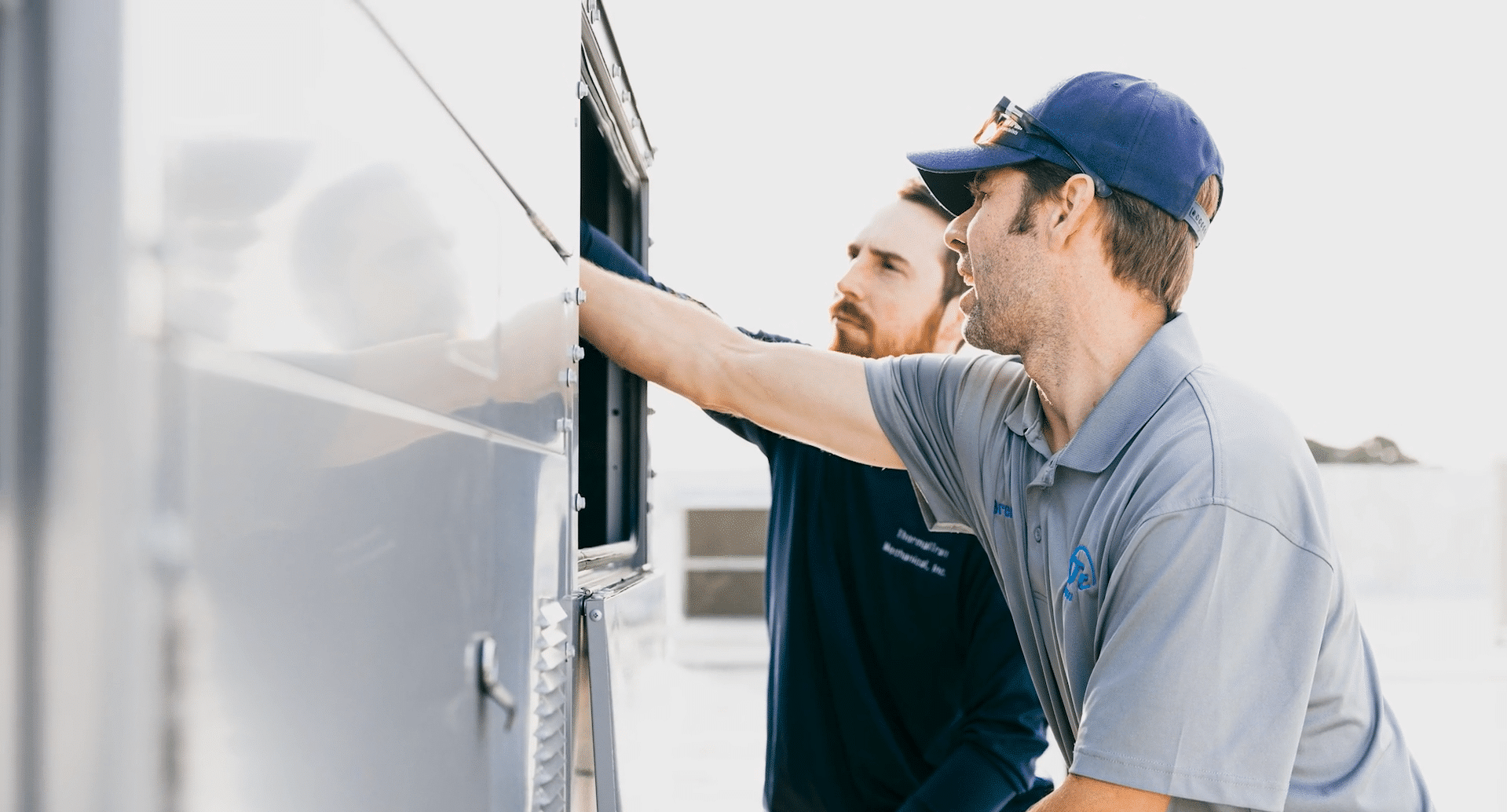 ThermalTran Mechanical Inc., based in Wilmington, NC. HVAC Contractor. 2 men looking at hvac unit