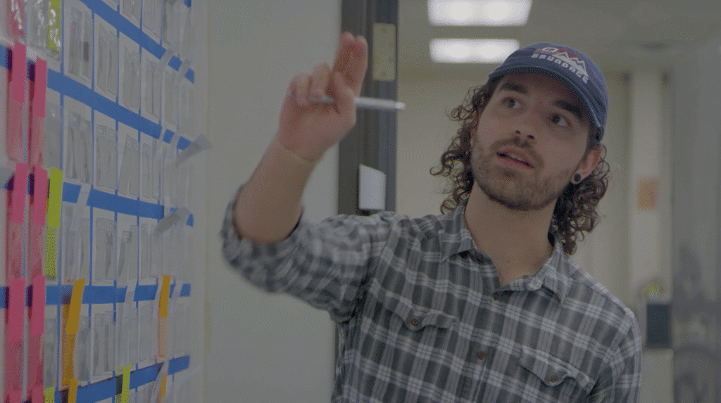 Waggoner Manufacturing in Round Rock, Texas. Young man in hat pointing to info on the walls.