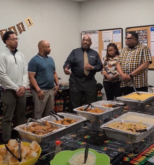 Career development at Cogent Analytics. group standing in front of food at event.