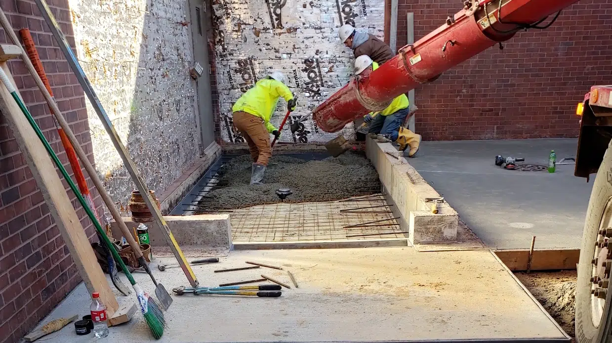 Construction workers pouring concrete at a job site