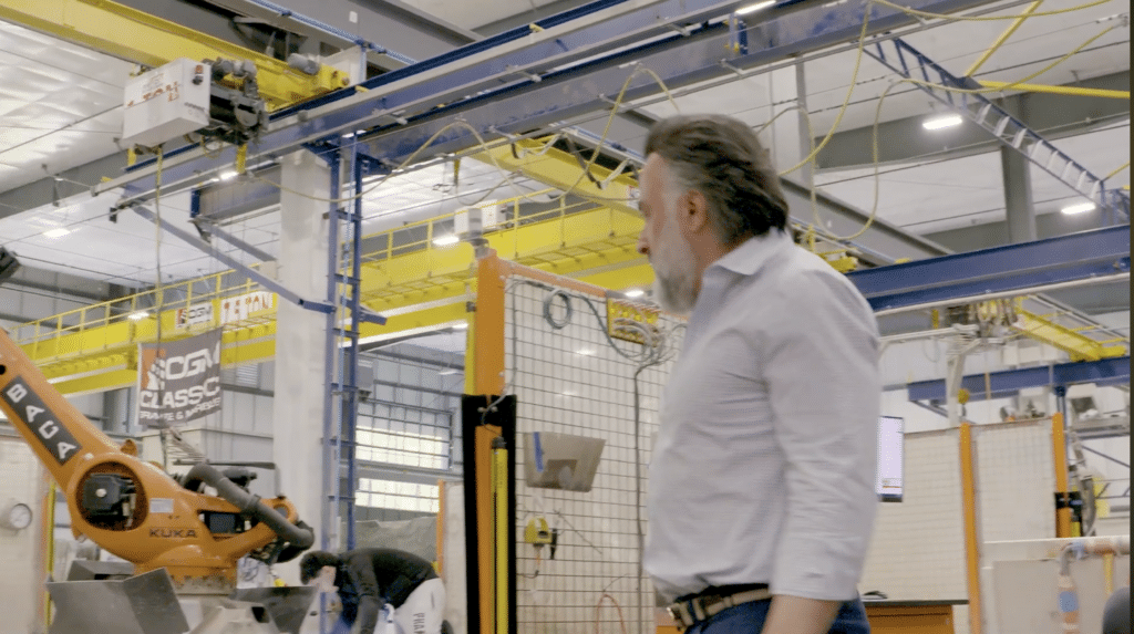 The owner of a manufacturing company on the shop floor looking at machinery