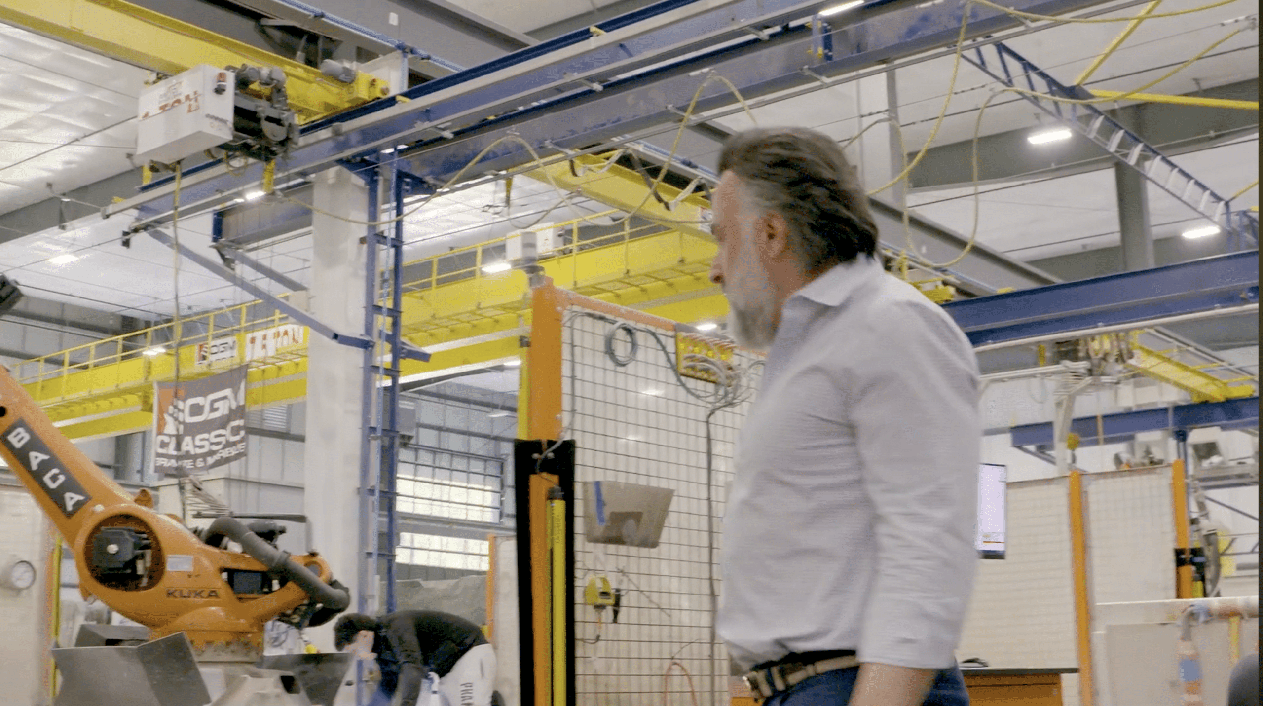 The owner of a manufacturing company on the shop floor looking at machinery