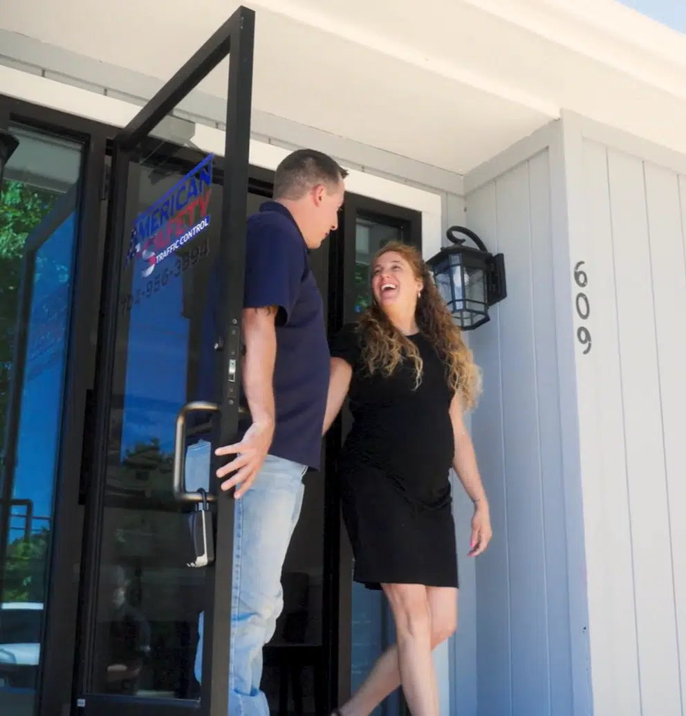 Husband and wife business owners smiling as they leave work for the day