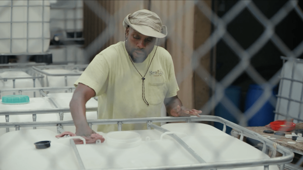 An employee at a chemical manufacturing facility wiping down a barrel.