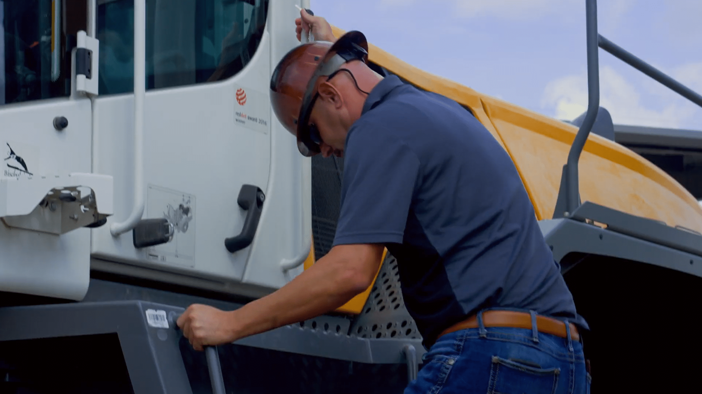 A contractor in a hard hat climbing out of a truck cab