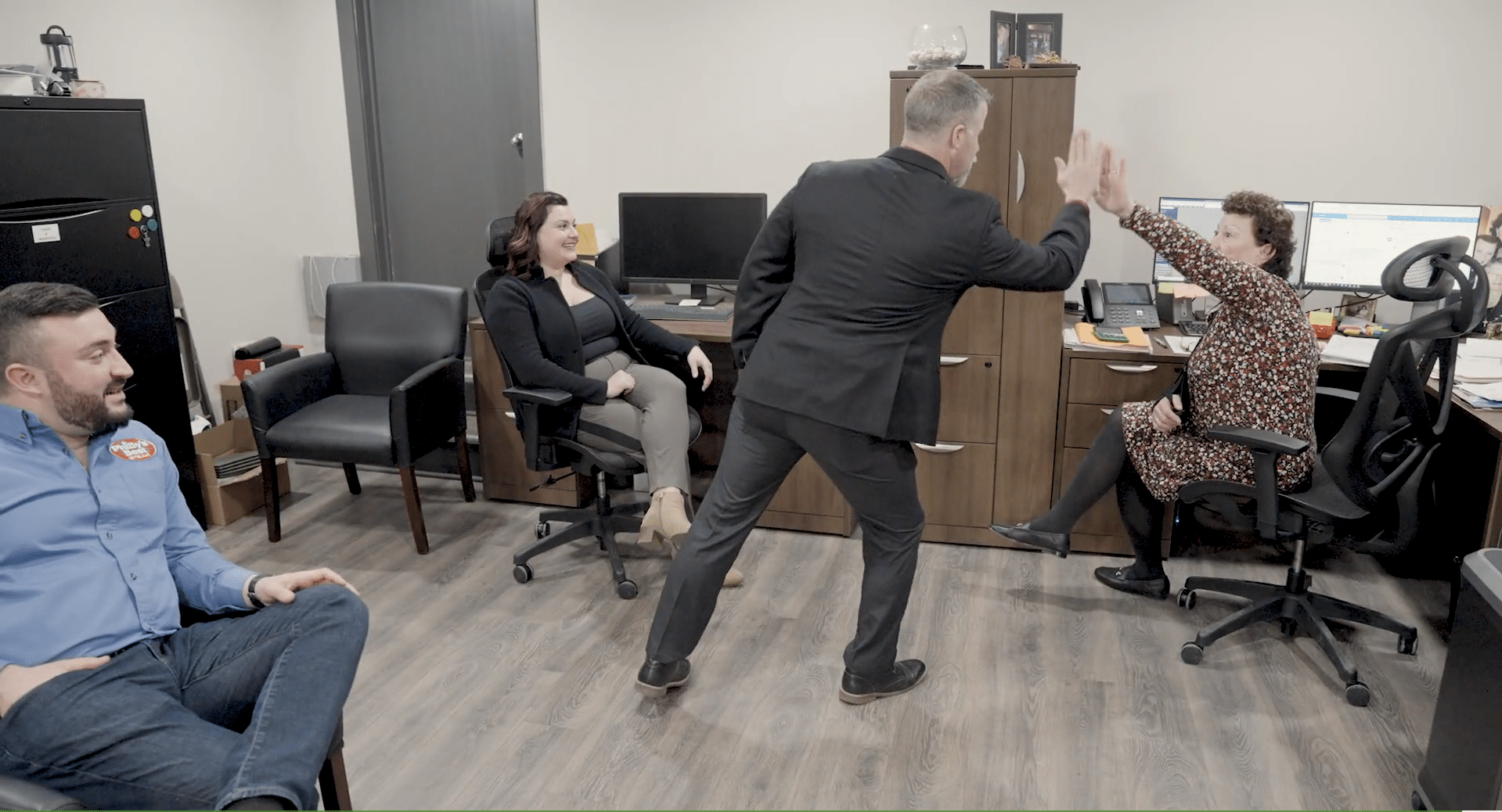 A business advisor high-fiving office members