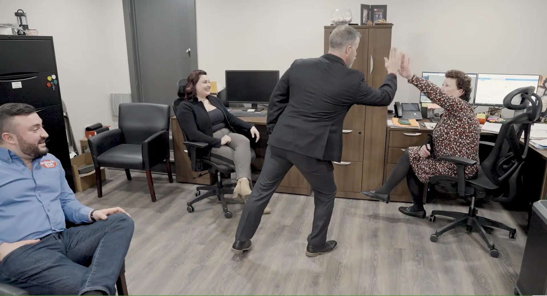 A business advisor high-fiving office members
