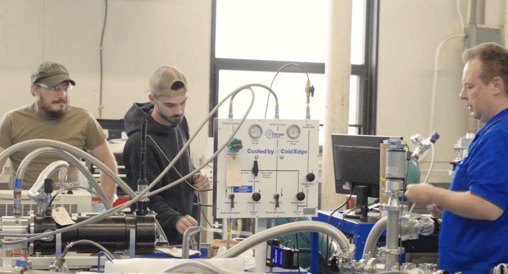 Three employees in a lab working with equipment