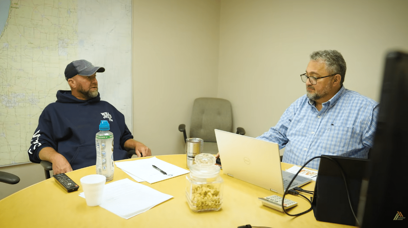 Two men at a conference table engaged in discussion