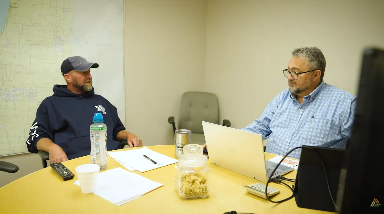 Two men at a conference table engaged in discussion