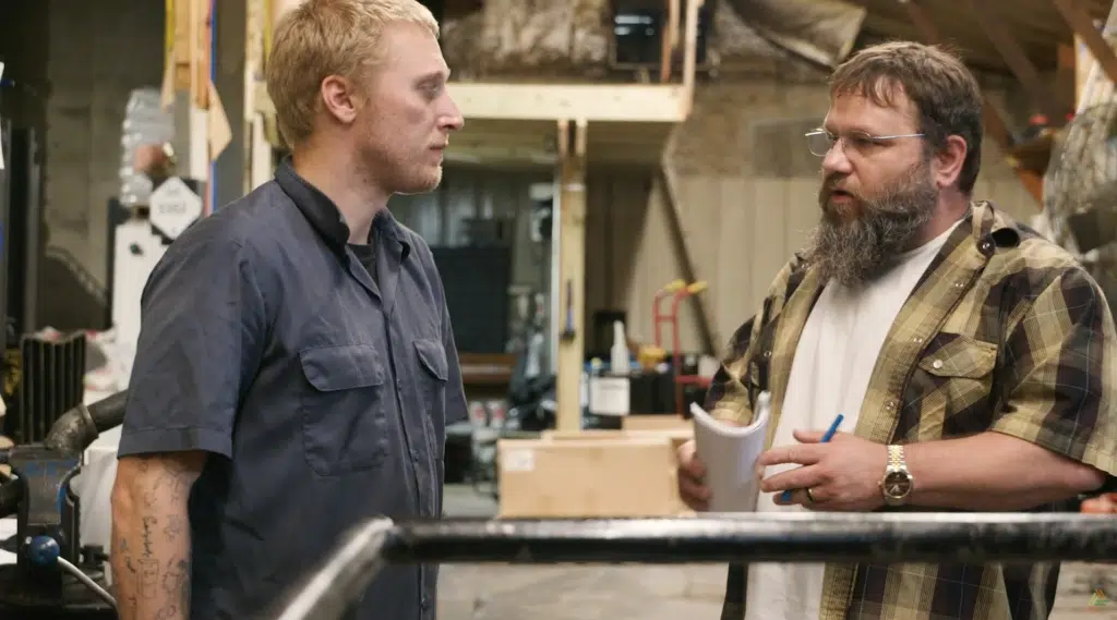 Two men on a shop floor having a discussion.
