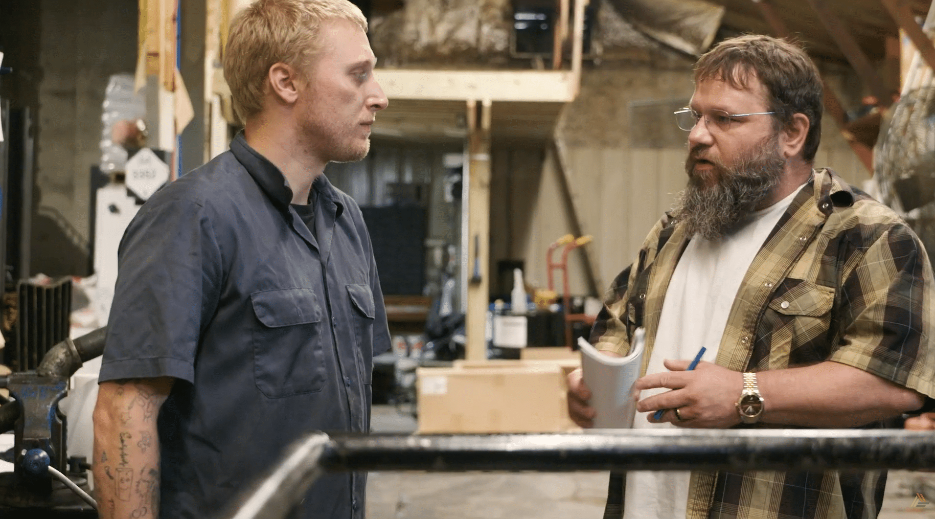 Two men on a shop floor having a discussion.