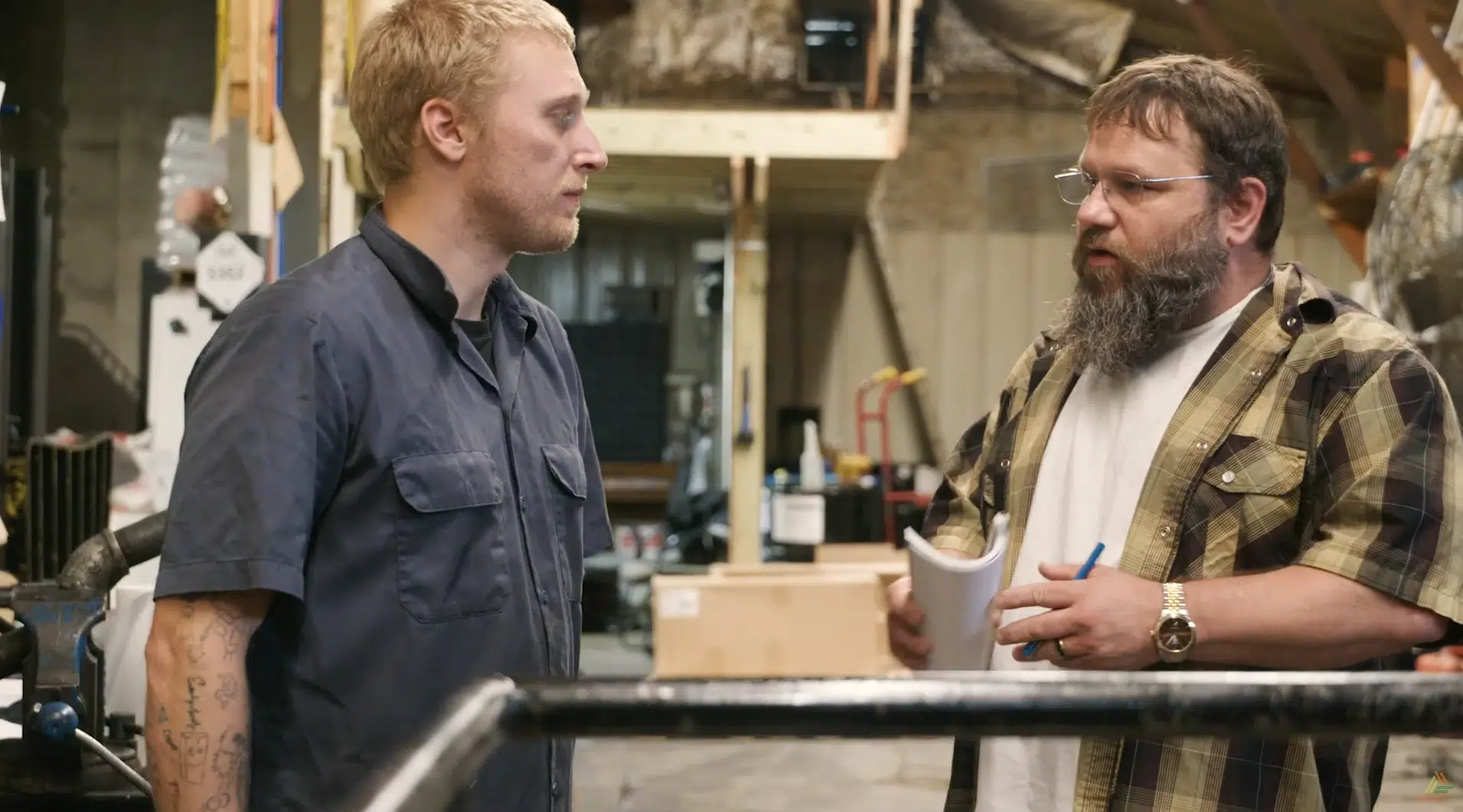 Two men on a shop floor having a discussion.